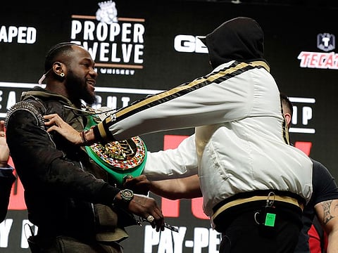 Tyson Fury, right, shoves Deontay Wilder during a face off for photographers at a news conference for their upcoming WBC heavyweight championship boxing match on Wednesday
