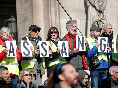 FILE PHOTO: Protesters hold signs demanding freedom for Wikileaks founder Julian Assange in front of the Opera Garnier in Paris, France, February 17, 2020. REUTERS/Charles Platiau/File Photo