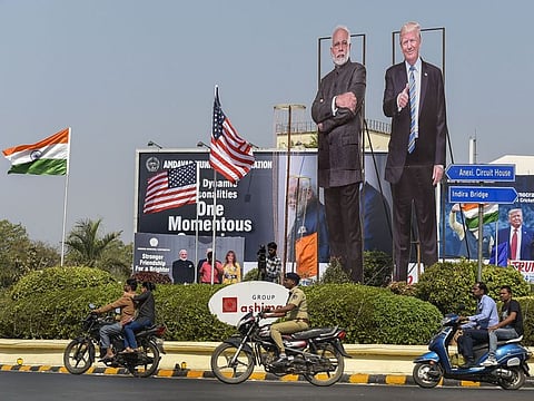 Bikers ride past life-size cut-outs of Prime Minister Narendra Modi and US President Donald Trump on a street, ahead of Trump's maiden visit to India, in Ahmedabad on February 23.