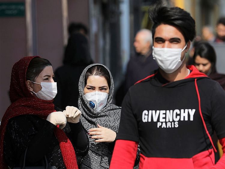Pedestrians wear masks to help guard against the Coronavirus, in downtown Tehran. 