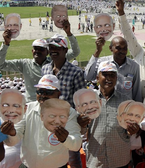 Indians hold masks of US President Donald Trump and Indian Prime Minister Narendra Modi and cheer as they attend the Namaste Trump event at Sardar Patel Stadium in Ahmedabad on Monday.
