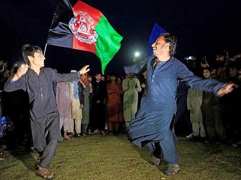 Afghan men celebrate in anticipation of the US-Taliban agreement to allow a US troop reduction and a permanent ceasefire, in Jalalabad, Afghanistan, on February 28, 2020. 