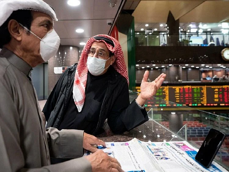 Kuwaiti traders wear protective face masks, following the outbreak of the new coronavirus, as they stand on the upper floor since the lower main hall is closed to traders at the Kuwait Boursa stock market trading in Kuwait city, Kuwait March 1, 2020. REUTERS/Stephanie McGehee