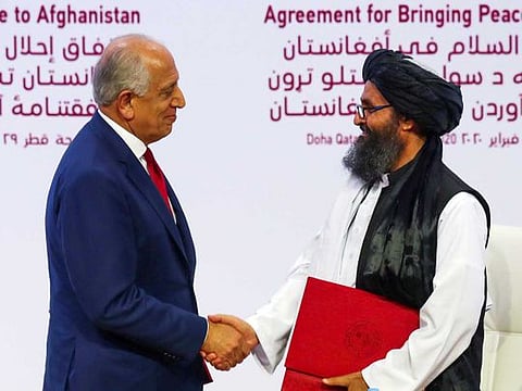 Mullah Abdul Ghani Baradar, the leader of the Taliban delegation, and Zalmay Khalilzad, US envoy for peace in Afghanistan, shake hands after signing an agreement at a ceremony between members of Afghanistan's Taliban and the US in Doha