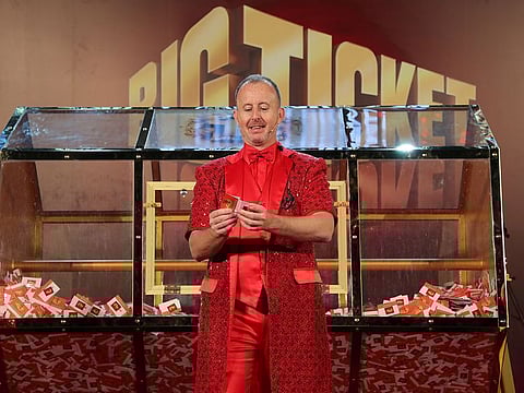 Thousands of people wait all over the world in bated breath to hear this man call out their name. He has a personality of a showman. And his sequined ensemble which he dons every time he goes on the big stage does no justice to undertone his glamourous presence. 