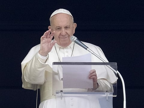 Pope Francis delivers his blessing as he recites the Angelus noon prayer from the window of his studio overlooking St.Peter’s Square, at the Vatican,  on Sunday.