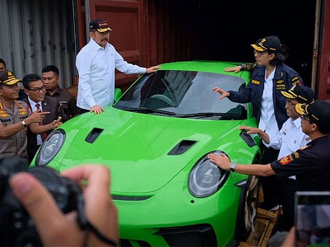  Indonesia's Finance Minister Sri Mulyani Indrawati (top R) gesturing next to a seized luxury car during a raid in Jakarta.