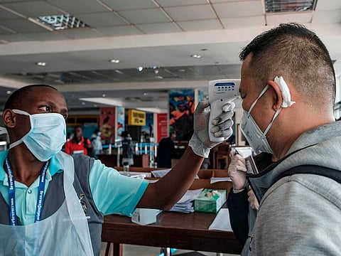 A passenger originating from China has his body temparature taken upon arrival on an international flight as he waits to be screened for signs of the novel coronavirus at Entebbe Airport on March 3, 2020. 