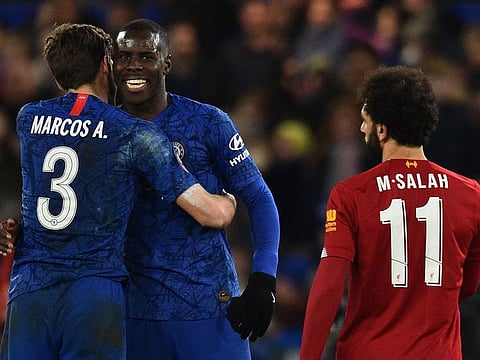 Chelsea’s Marcos Alonso (L) and Kurt Zouma celebrate as Liverpool’s Mohamed Salah walks off.