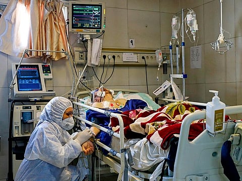 An Iranian medic treating a patient infected with coronavirus at a hospital in Tehran on Sunday