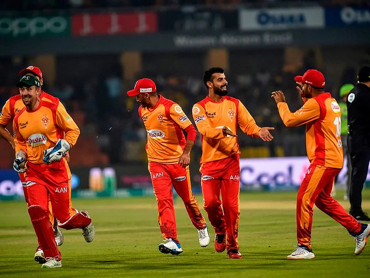 In this photo taken on March 4, 2020, Islamabad United's cricketers celebrate after the dismissal of Lahore Qalandars's Samit Patel during the Pakistan Super League (PSL) T20 cricket match between Lahore Qalandars and Islamabad United at the Gaddafi Cricket Stadium in Lahore.  / AFP / Arif ALI