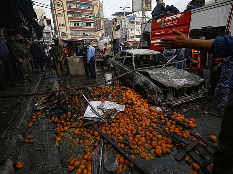 Fruit is scattered accross the street near a charred car after a fire that broke out in a market in the refugee camp of Nuseirat in central Gaza Strip on Thursday.