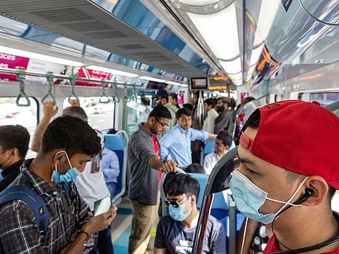 Commuters, some of which were wearing protective masks, riding the metro in Dubai.