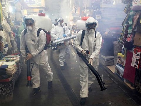 Firefighters disinfect a traditional shopping center to help prevent the spread of the new coronavirus in northern Tehran, Iran