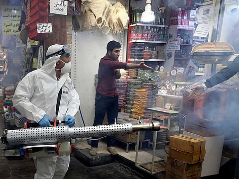 A firefighter disinfects a traditional shopping center to help prevent the spread of the new coronavirus in northern Tehran, Iran, Friday, March, 6, 2020.  