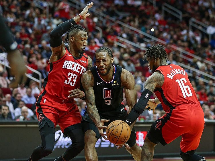 Los Angeles Clippers forward Kawhi Leonard attempts to control the ball as Houston Rockets forward Robert Covington (33) and guard Ben McLemore (16) defend