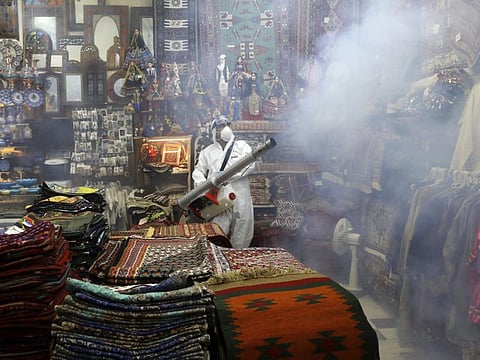 A firefighter disinfects a traditional shopping center to help prevent the spread of the new coronavirus in northern Tehran on March 6.