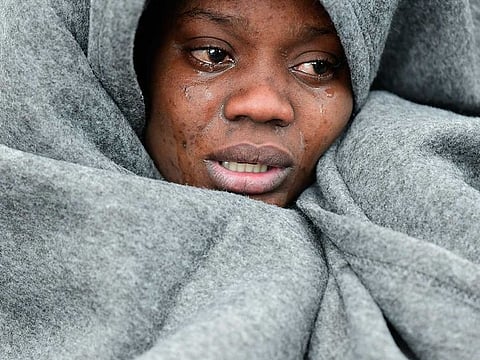 A migrant cries as she tries to warm herself as she and others arrive at the village of Skala Sikaminias, on the Greek island of Lesbos, after crossing the Aegean sea from Turkey
