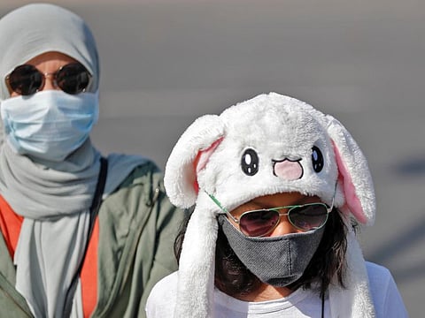 Tourists wearing protective masks walk in a street following an outbreak of the coronavirus disease, in New Delhi on March 9.