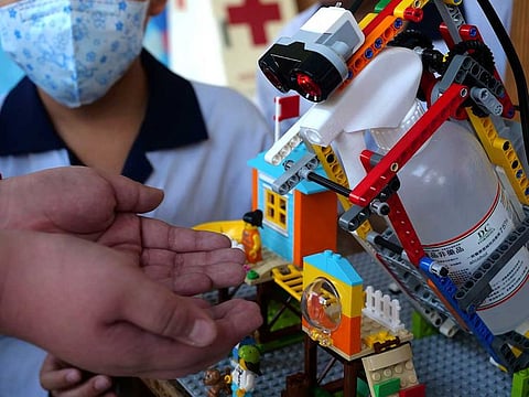 An elementary school student uses a self-built motion sensor controlled disinfectant dispenser assembled with Lego parts, following a novel coronavirus outbreak, in the southern Taiwanese city of Kaohsiung, Taiwan.