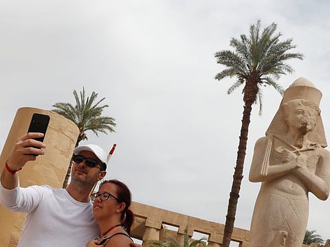 Tourists take a selfie picture with a mobile phone during their visit to Karnak Temple, following an outbreak of the coronavirus, in Luxor.