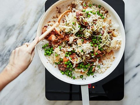 Crispy fried rice with bacon and cabbage cooks in a pan, in New York, Feb. 14, 2020. The secret to crisp, crunchy rice? Stir less, fry more. Food Stylist: Rebecca Jurkevich. (Linda Xiao/The New York Times)