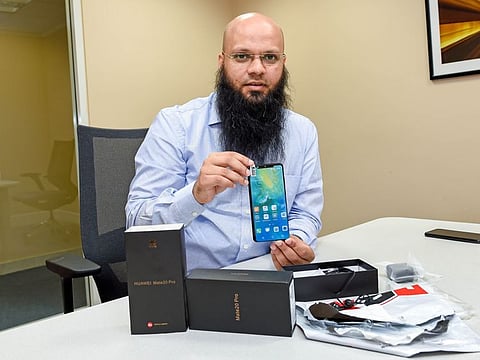 Ajman-based Indian expat Saleemuddin Ansari with the fake phone he received via courier 