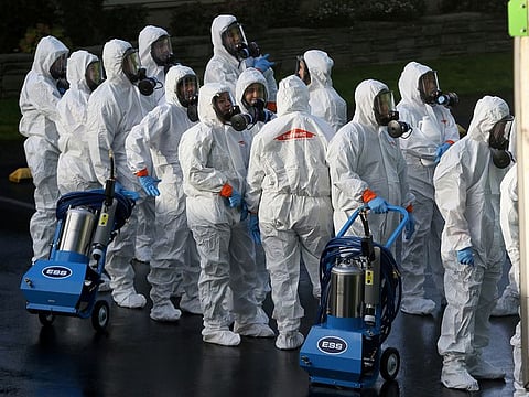 Members of a Servpro cleanup crew wearing hazardous material suits prepare to enter Life Care Center of Kirkland, the Seattle-area nursing home at the epicenter of one of the biggest coronavirus outbreaks in the United States, in Kirkland, Washington, U.S. March 11, 2020. 