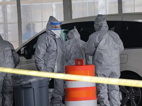 Workers in protective gear operate a drive through COVID-19 mobile testing centre on March 13, 2020 in New Rochelle, New York. The center serves all parts of Westchester County and will test up to 200 people today, growing to up to 500 people per day in the coming days.