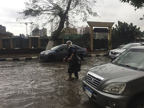 A man wears makeshift rain gear as he navigates a flooded road after heavy rains in the Zamalek district of Cairo, Egypt, Thursday, March 12. Thunderstorms packing heavy rains and lightning caused widespread flooding in Egypt on Thursday, killing several people and causing authorities to shut down schools and an airport, officials said. 