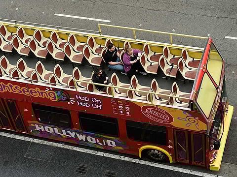 Passengers sit in a mostly empty sightseeing bus on Hollywood Boulevard in the Hollywood section of Los Angeles.