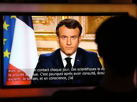 French President Emmanuel Macron is seen on a television screen as he speaks during a televised address to the nation on the outbreak of COVID-19, caused by the novel coronavirus, on March 16, 2020, in Paris. 