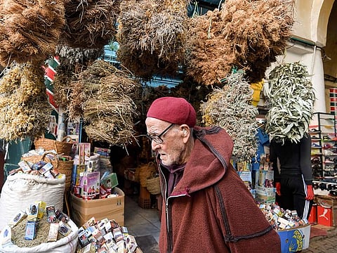 A Tunisian man walks past a herbalist's shop selling medicinal plants at Souk Al Blat, in the Medina (old city) of Tunisia's capital Tunis, on March 14, 2020. 