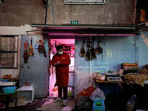 A man wears a protective face mask at a butcher shop following an outbreak of coronavirus disease (COVID-19), in downtown Shanghai, China March 16, 2020.