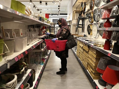 A woman wearing a face mask shops at a store in Bamland shopping mall, in Western Tehran on March 15.