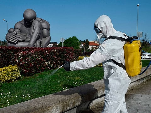 A member of the Military Emergencies Unit (UME) carries out a general disinfection outside the Alvaro Cunqueiro hospital in Vigo, on March 18, 2020. 