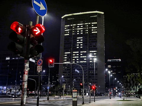 Office lights of the Lombardy region headquarters building in Milan, northern Italy, compose the Italian words 'State a casa' (Stay home), Wednesday, March 18, 2020. 