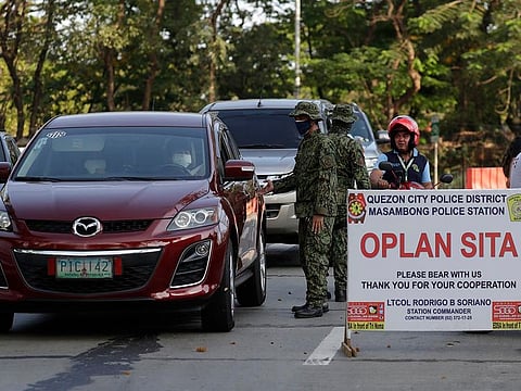 Police stop motorists at a checkpoint in Metro Manila, Philippines on Wednesday, March 18, 2020. 