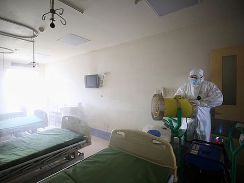 A worker disinfects a room at the Red Cross hospital in Wuhan, in China's central Hubei province on March 18, 2020.