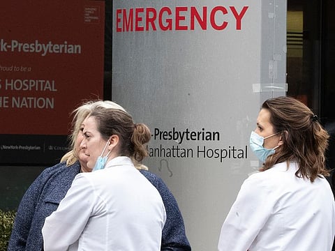 Medical personnel talk outside the emergency room at NewYork-Presbyterian Lower Manhattan Hospital in New York. 