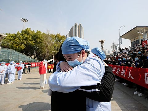A local medical worker embraces and bids farewell to a medical worker from Jiangsu at the Wuhan Railway Station as the medical team from Jiangsu leaves Wuhan, in Hubei province, China March 19, 2020. 