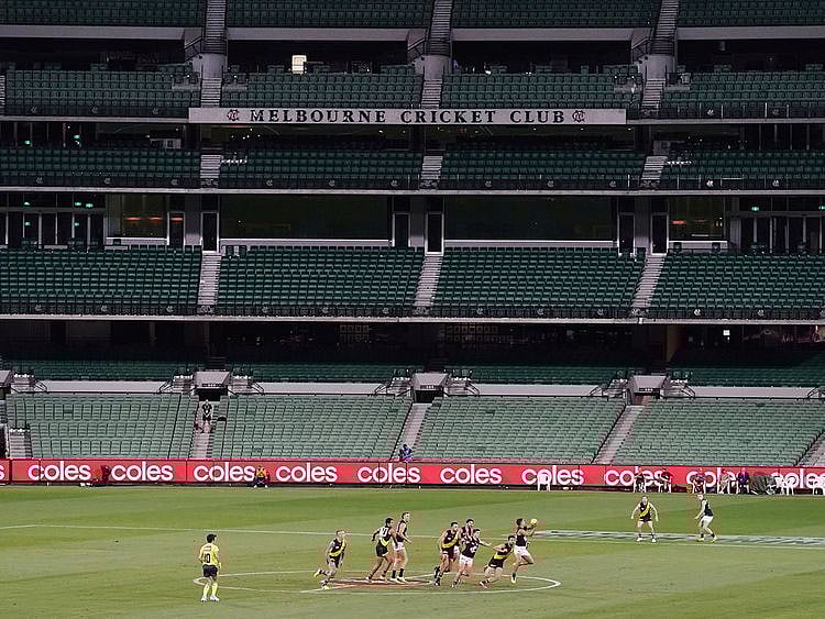 Players from Richmond and Carlton play their Australian Rules Football league game at a empty Melbourne Cricket Ground in Melbourne, Thursday, March 19