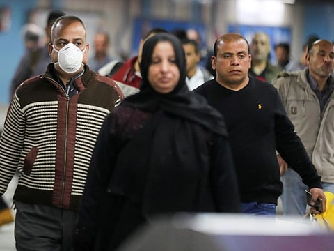 A man wearing a protective face mask walks at the underground Al Shohadaa metro station in Cairo. Both Egypt and Kuwait have already halted flights with the outside world as part of their precautions to contain the spread of the new coronavirus.