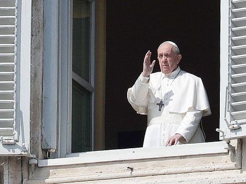 Pope Francis salutes from the window of the apostolic palace overlooking an empty St.Peter's square after his livestreamed the Angelus prayer on March 22, 2020 at the Vatican.   