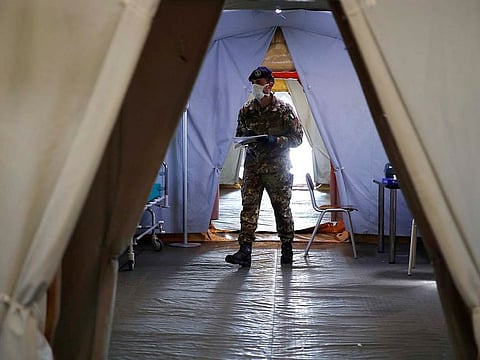 An Italian soldier walks inside the field hospital built in Crema, Italy, Tuesday, March 24, 2020. 