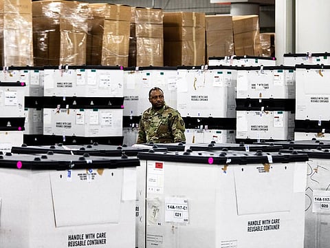 A member of the state National Guard stands amidst crates of supplies as a field hospital is set up inside the Jacob K, Javits Center on the West Side of Manhattan on Monday, March 23, 2020. 