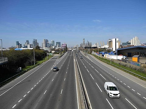 A small amount of traffic travels on the Blackwall Tunnell Southern Approach on the A102 road south east of London, backdropped by the Canary Wharf financial district, on the morning on March 24, 2020 after Britain's government ordered a lockdown to slow the spread of the novel coronavirus.