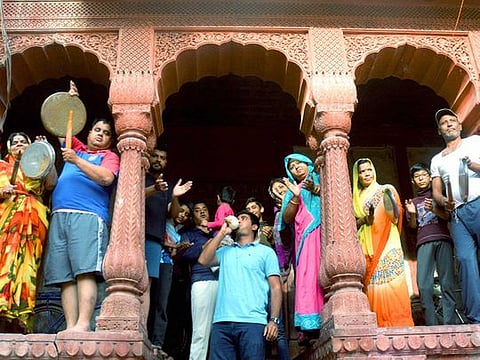 People clap and clang utensils as a gesture to show gratitude to the helpers and medical practitioners who are working relentlessly to fight coronavirus during Janta curfew, in Bikaner on March 22, 2020. 