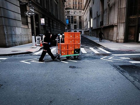 A man makes deliveries near Wall Street as people stay away from the area due to the coronavirus on March 24, 2020 in New York City.