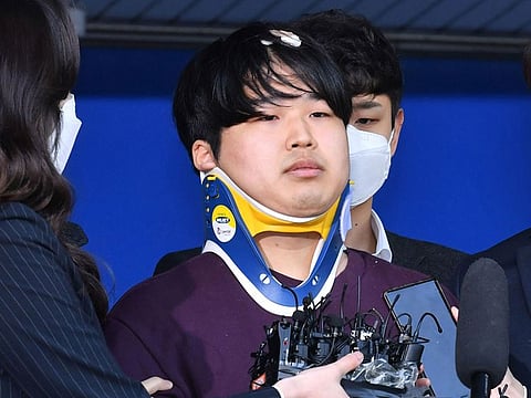 South Korean suspect Cho Ju-bin (C) is surrounded by reporters as he is transferred to a prosecutor's office, at a police station in Seoul on March 25, 2020. 